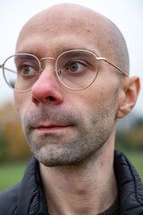 Obraz premium Man in glasses looking away, reflecting. Eyewear style, human eyesight, and introspective moment, contemporary style, intellectual look, male portrait