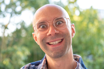 happy positive caucasian young man 30-35 years old smiling on green natural background, good mood, age-related changes, mental human health