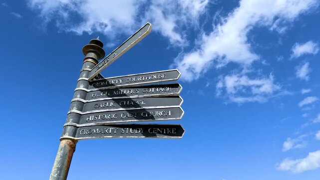 Rotating Directional Signpost Against Blue Sky in Cromarty