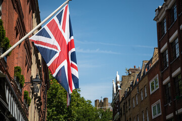 Union Jack flag on a flagpole against a clear blue sky, representing the United Kingdom&rsquo;s national identity, pride, and heritage.