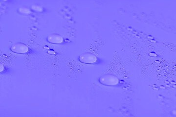a smooth purple surface covered with water droplets, a beautiful wet purple film in a large number of water droplets