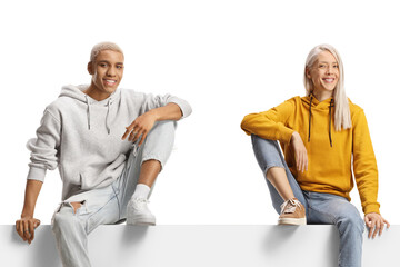 Caucasian female and african american guy sitting on a blank panel