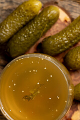 marinated and pickled cucumbers close up, poured pickle with spices and cucumbers on a board
