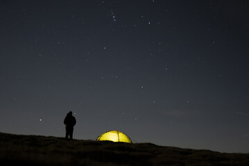 Man and wild camping tent under the night sky, amazing scene © UAV4