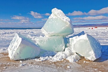 Ice chunks on snowy shore, sunny day