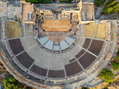 Aerial view of the ancient Teatro Greco, its stone seating contrasting with the bright stage, a relic of history viewed from above, Taormina, Sicilia, Italy.