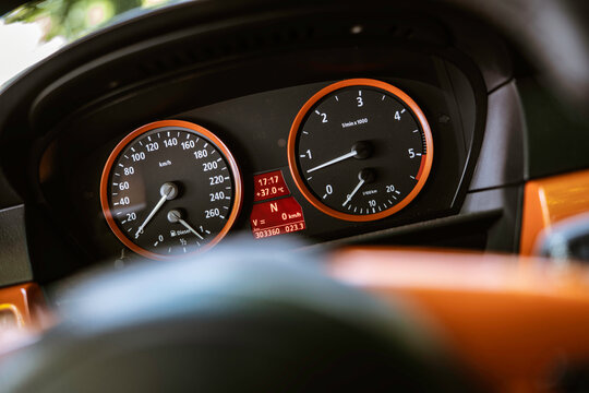 Close-up of car dashboard showing speedometer, tachometer, and digital display