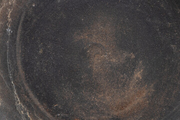 Ceramic flat plate with dark brown coating and dust and dirt stains, used for background or texture