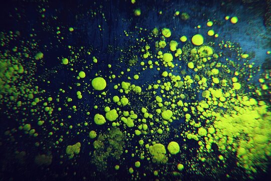 Abstract vibrant, glowing, yellow-green orbs on a dark, textured surface