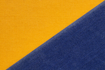 Fototapeta premium Orange fabric and blue fabric in a diagonal arrangement, close-up texture, covers of two old books