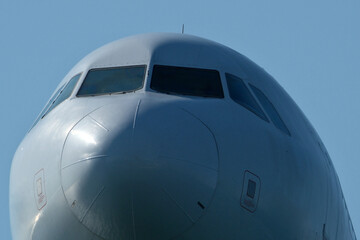 Close-Up of Passenger Jet Nose and Cockpit Windows. Airplane in the blue sky, close-up of the plane