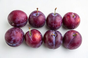 Obraz premium Fresh ripe plums arranged on a white background