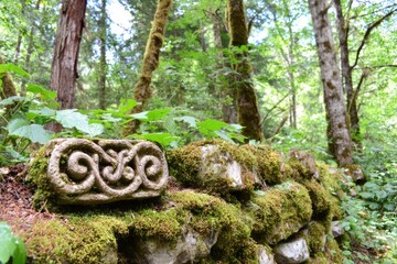 Ornate stone fragment in mossy forest