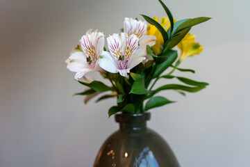 Elegant floral arrangement with white and yellow flowers in a decorative vase
