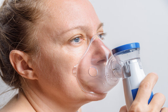 Sick woman is using nebulizer at home