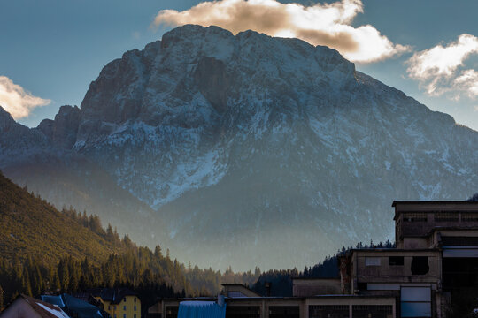 vista dettagliata del monte Cima del Lago, che si erge sopra il paese di Cave del Predil, nel Friuli Venezia Giulia nord orientale, di pomeriggio, in inverno, con cielo sereno
