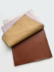 Samples of colored leather for sewing clothes on a white background. An element of the work of a fashion designer and tailor