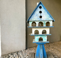 Rustic blue wooden birdhouse with weathered texture, perfect as a charming accent for gardens, patios, and outdoor decor in a vintage or countryside style.