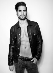 Obraz premium Handsome young and alethic man with six pack in leather jacket