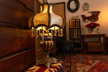 old fashioned lamp in the room, warm indoor yellow light, bookshelf and mirror with wooden frame