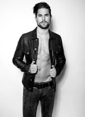 Handsome young and alethic man with six pack in leather jacket
