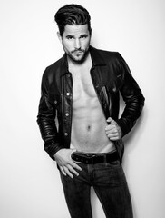 Handsome young and alethic man with six pack in leather jacket