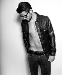 Handsome young and alethic man with six pack in leather jacket