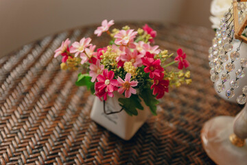 bouquet of pink and yellow flowers in a vase, bamboo table, home decoration