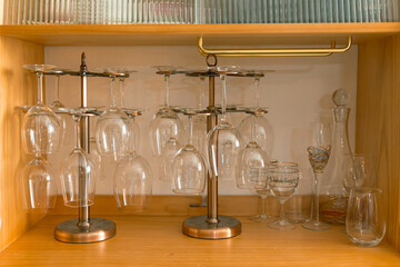glasses on the wooden shelf, rack with many wine glasses, a corner in the home kitchen