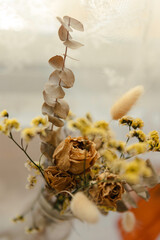 spring dried flowers in a vase, floral decoration art in a natural light background, bright sun light from the window