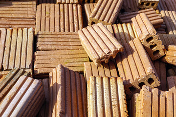 Pile of bricks for construction work, brown brick background, Close-up of stacked bricks ready to be used as a construction material.