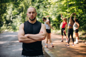 Obraz premium Man is standing in front of people. Group of runners are together outdoors
