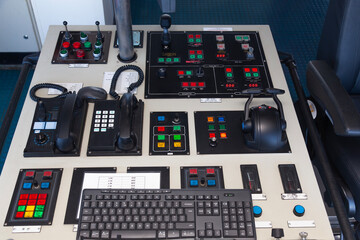 A control panel for a sea ship with various buttons, levers and switches.