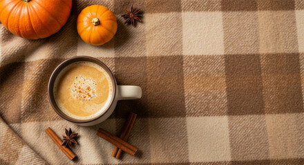 greeting card background with warm cup of coffee with pumpkins and cinnamon on plaid blanket