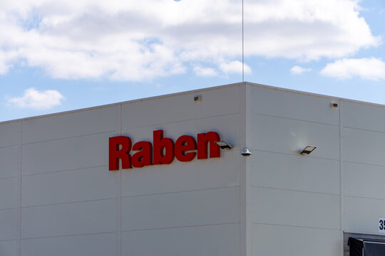 Raben company building with red logo on white facade under bright sky