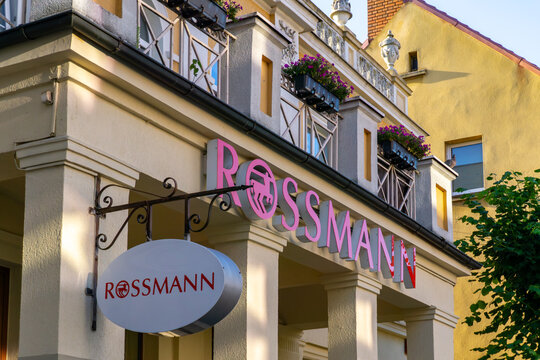 Rossmann sign on the facade of a building with balcony and flowers, side view