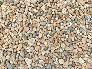 Natural river stones create a textured surface perfect for landscaping and decorative uses in outdoor settings
