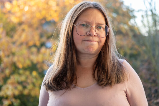 skeptical woman narrows eyes, expression filled with doubt in natural setting, raised eyebrow and tight lips convey skepticism in intimate nature portrait, unexpected doubts, mistrust