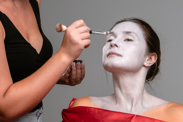 Obraz premium Professional Makeup Artist Applying White Face Paint for Cosplay
