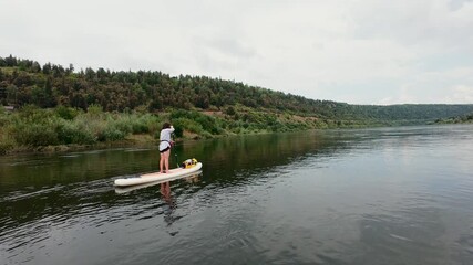 Join us for an exhilarating paddleboarding adventure on a serene and peaceful river, surrounded by lush greenery and breathtaking hills, ideal for outdoor enthusiasts and adventurous spirits alike