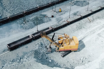 Loading of crushed stone into trolleys on the railway track.