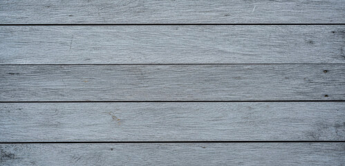 Gray wooden planks form a textured background with horizontal lines and subtle shadows, displaying a rustic weathered surface that adds depth and warmth to the overall composition.