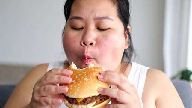 ハンバーガーを食べる体重100kg超えの肥満女性