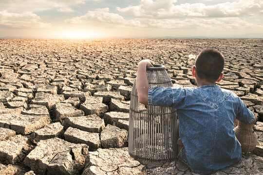 Child in drought-stricken arid areas struggling with deprivation and fighting to survive amidst harsh cracked soil and scorching heat.