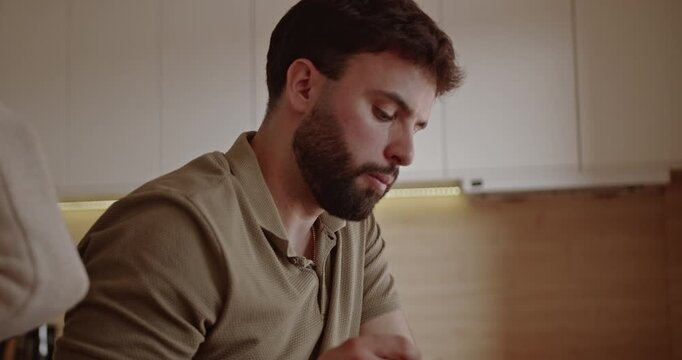 A young couple enjoys a healthy meal together in their modern kitchen. They share a moment of connection and contentment as they savor their food.