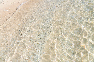 波によって砂浜に描かれた光の模様