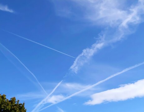 Blue sky with jet trails and clouds