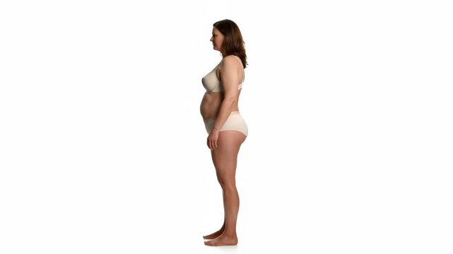 Plus-size woman in lingerie on a plain background, body positivity and self-confidence concept indoors