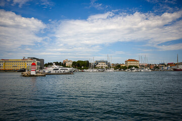 Obraz premium Scenic view of zadar harbor with boats moored and lighthouse, under a bright blue sky