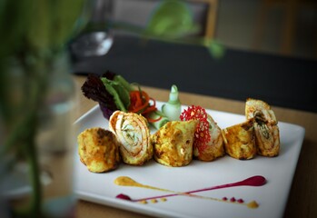 Soya chaap garnished with veggies on a black plate